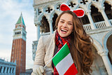 Woman tourist showing Italian flag on Piazza San Marco in Venice