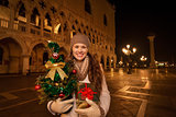 Woman with Christmas tree and gift box on Piazza San Marco
