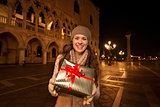 Woman showing Christmas gift box on Piazza San Marco, Venice