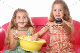 shot of happy children watching a movie eating popcorn