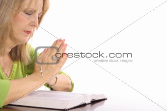 shot of a woman praying over bible
