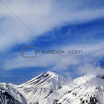 Winter snowy mountains and sky with clouds at nice day