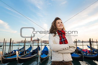 Happy woman traveler standing on embankment in Venice, Italy