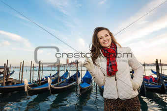 Woman standing on embankment and pointing on copy space, Venice