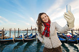 Happy woman traveler taking selfie on embankment in Venice