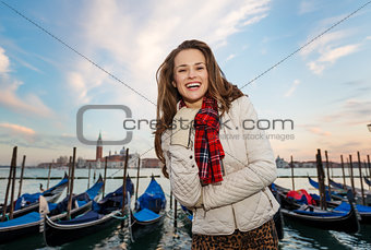 Portrait of happy woman traveler on embankment in Venice, Italy