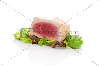 Delicious tuna steak on green salad.