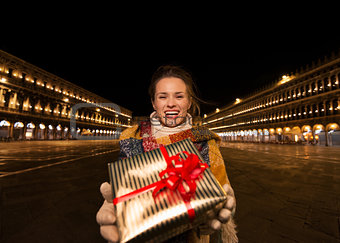 Happy woman with Christmas gift box on Piazza San Marco, Venice