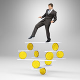 Businessman standing on balance with gold coins