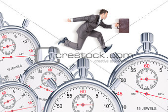 Businessman running with set of timers