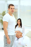 a man standing next to his pregnant