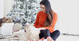 Laughing young woman with her dog at Christmas