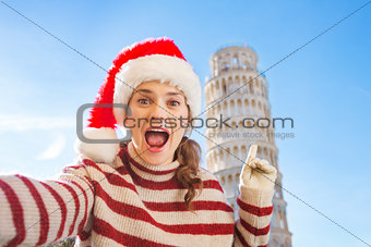 Woman in Santa hat taking selfie in front of Leaning Tour, Pisa