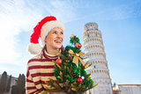 Woman in Santa hat with Christmas tree near Leaning Tour, Pisa