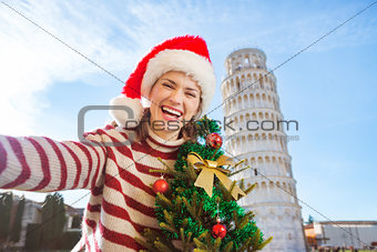Woman with Christmas tree taking selfie near Leaning Tour