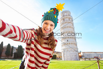 Woman in Christmas tree hat taking selfie in Pisa