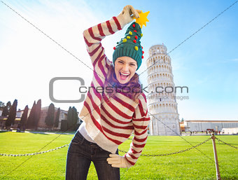Woman make fun of Christmas tree hat near Leaning Tour of Pisa