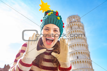 Woman in Christmas tree hat shouting in front of Leaning Tour