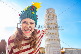 Woman in Christmas tree hat pointing on Leaning Tour of Pisa