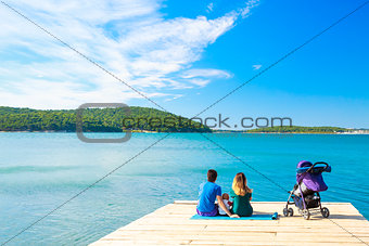 Family with Little Baby Sitting on Pier near the Sea