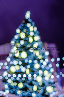 Decorated Christmas tree. Blurred lights background
