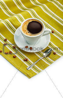 White porcelain cup with coffee on napkin