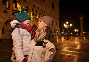 Happy mother with camera and child on Piazza San Marco in Venice