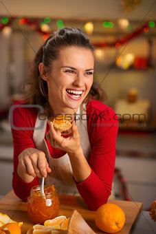 Housewife tasting orange marmalade in Christmas kitchen