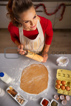 Housewife with rolling pin cooking Christmas cookie in kitchen