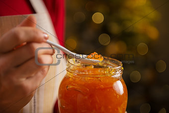 Closeup on a spoon of homemade marmalade in hand of housewife