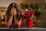Frustrated woman waiting for a phone call in Christmas kitchen