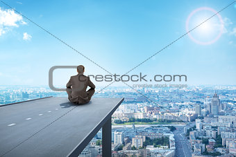 Businessman sitting on road with city