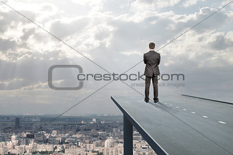 Businessman standing on road in sky