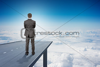 Businessman on road in sky, rear view