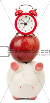 Fresh red apple with alarm clock and piggy bank