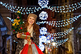 Woman with Christmas tree, gift and shopping bags in Venice