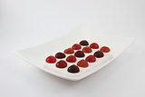 Heart shape colorful jelly are arranged on the white plate on white background side view