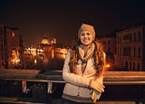 Happy young woman standing on a bridge overlooking Grand canal