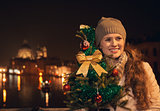 Happy woman with Christmas tree standing on a bridge in Venice