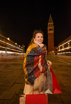 Woman with shopping bags on Piazza San Marco in evening, Venice