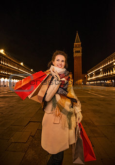 Playful woman holding shopping bags on Piazza San Marco, Venice