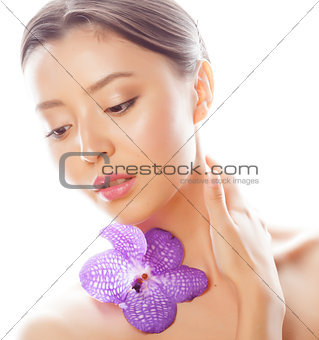 young pretty asian woman with flower orchid close up isolated spa
