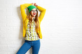 Smiling Hipster Girl at White Brick Wall Background