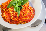 Plate of spaghetti bolognese with basil garnish