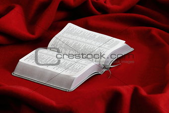 book on a red velvet. Bible.