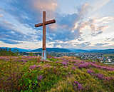 Summer evening country view with wooden cross 