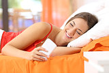 Teen using a smart phone in the bed