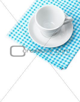 White porcelain mug with saucer tableware on cellular napkin