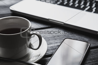 Office table with notepad, computer and tea cup