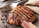 Magnifying glass examining beef steak
